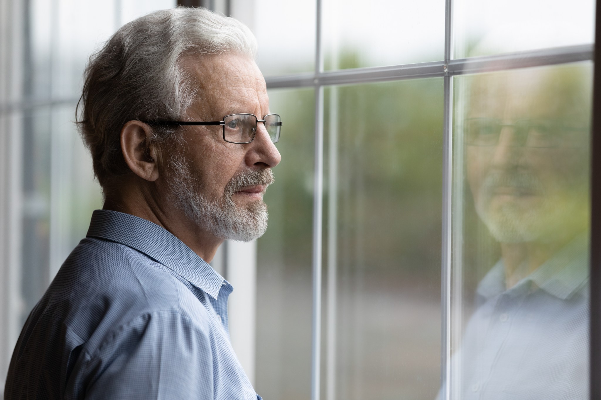 Un homme pensif regarde par la fenêtre